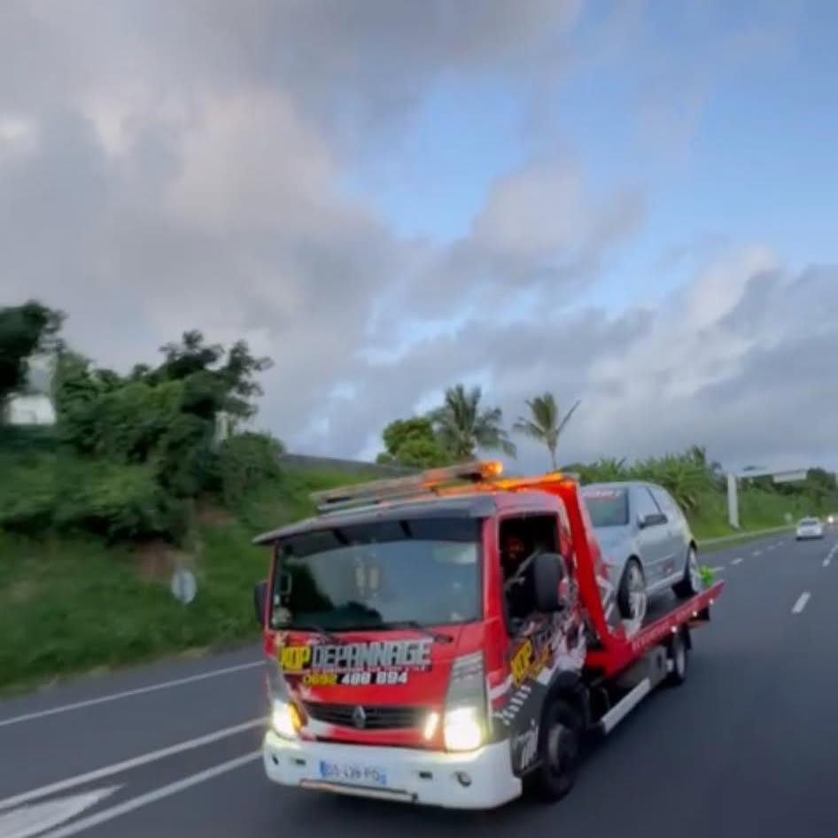 Le camion plateau KDP Dépannage transportant une voiture sur la quatre-voies